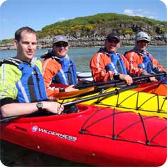 A group enjoy kayaking near Plockton on a beautiful sunny day.